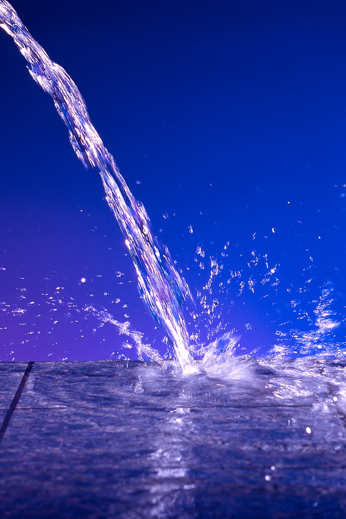 Blauer Wasserstrahl mit Spritzern